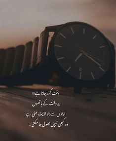 a watch sitting on top of a wooden table next to an arabic quote about time