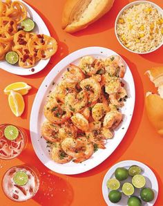 there are many different types of food on the table, including shrimp and limes