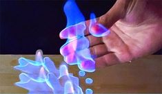 two hands are shown with blue light coming out of them, and one hand is holding something