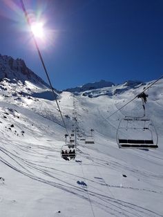 a ski lift going up the side of a snow covered mountain