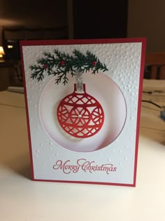 a christmas ornament hanging from a card on a table