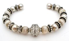 Fine Jewellery - This is a sterling silver cuff bracelet loaded with fluted, plain and antiqued ornate beads and spacers. It has an inside circumference of 5.25", opening is 1.25", slightly flexible, comfortable putting on and off, weight is 30.8 grams, no marks. The bead on one end can be unscrewed and beads can be removed, if desired.