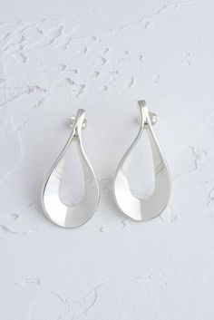 Flat Teardrop Sterling Silver EarringsSpecification:Type: Stud EarringMaterial: 925 Sterling SilverDimensions: H: 35mm, W: 22mm These unusual sterling silver stud earrings are quite unique, are totally modern and will go with almost every outfit.  An amazing wedding gift or special birthday present, these striking Flat Teardrop earrings are perfect for making a bold statement.Customized in LondonOur customized jewelry is all done by hand so will delay the arrival by approximately 1 week.  You ca Modern Teardrop Sterling Silver Earrings, Modern Silver Drop Earring Set, Modern Dangle Teardrop Earrings For Anniversary, Modern Teardrop Earrings For Gift, Modern Teardrop Earrings For Anniversary, Silver Drop Pierced Earrings As Gift, Silver Teardrop Earrings With Polished Finish For Gift, Modern Sterling Silver Teardrop Earrings For Anniversary, Modern Long Drop Teardrop Earrings Gift