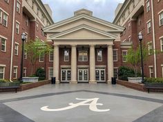 the front entrance to an university building with columns and pillars on either side of it