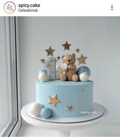 a blue cake with stars and a teddy bear on top