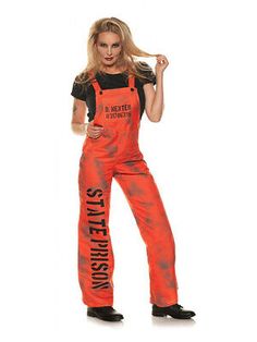 a woman in an orange tie dye overalls and black t - shirt is posing for the camera