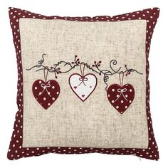 a decorative pillow with three hearts hanging from it's sides on a white background