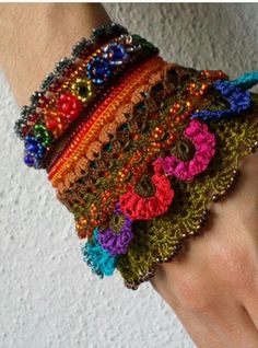 a woman's hand with several bracelets on it