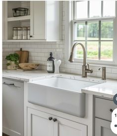 a white kitchen sink sitting under a window