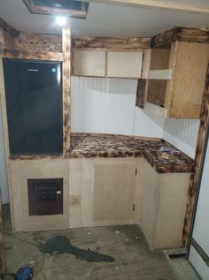 an unfinished kitchen with wooden cabinets and blackboard