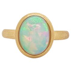 This opal ring is an incredible design with the opal the perfect size to show up but not overwhelm. Depending on the size of your fingers the ring can be a middle finger or pointer finger ring (if you have petite hands) or it can be a ring finger ring if you have medium to large hands. We hand picked this opal because the fire in it is incredible. The satin 14 karat yellow gold bezel is the perfect texture to pair with the opal. Australia is known for having the best opals and this ring will not disappoint. The details for this beautiful ring are listed below: Metal Quality: 18K Yellow Gold, Satin Finish Gemstone: Opal Gemstone Weight: 2.29 Carats Gemstone Color: Green and Pink with Peach Flecks Gemstone Shape: Oval Gemstone Measurements: 10.93 mm x 8.49 mm Band Width: 2.55 mm Ring Size: 6 Pointer Finger Ring, Oval Opal Ring, Opal Australia, Australian Opal Ring, Star Jewelry, Domed Ring, Opal Ring, Australian Opal, Ring Finger