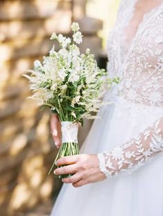 a bride holding a bouquet of flowers in her hand