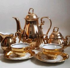 gold tea set with matching cups and saucers