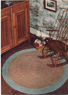 a rocking chair sitting on top of a rug next to a wooden cabinet and dresser