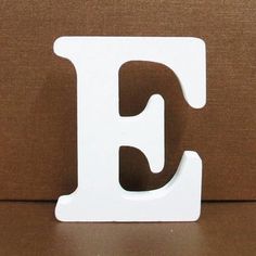 the letter e is made out of wood and sits on top of a brown surface