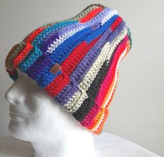 a white mannequin head wearing a multicolored knitted beanie hat