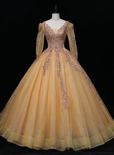 Experience the opulence of modern-day royalty in the dazzling Gold Tulle Long Sleeve Backless Sequins Quinceanera Dress. This enchanting ball gown exudes charm and elegance with its alluring V-neck and full, floor-length skirt that flows gracefully as you move. The delicate tulle fabric, in a radiant gold hue, sets the stage for a truly captivating ensemble. Tulle Quinceanera Ball Gown For Gala, Tulle Quinceanera Dress Ball Gown For Gala, Tulle Ball Gown For Quinceanera Or Gala, Princess Quinceanera Dress With Sweetheart Neckline For Gala, Quinceanera Dress With Sweetheart Neckline For Gala, Ball Gown Quinceanera Dress For Prom Season, Floor-length Tulle Ball Gown For Quinceanera, Tulle Floor-length Quinceanera Dress For Debutante Ball, Floor-length Tulle Quinceanera Dress For Debutante Ball