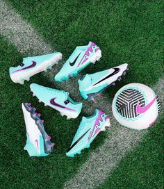 several soccer shoes and a ball on the grass