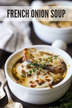 two bowls filled with french onion soup on top of a table