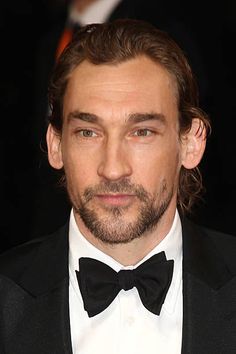 a close up of a person wearing a tuxedo and bow tie at an event