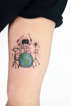 a small tattoo on the leg of a person with an astronaut and earth in the background