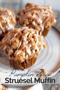 some muffins are sitting on a plate with icing drizzled over them