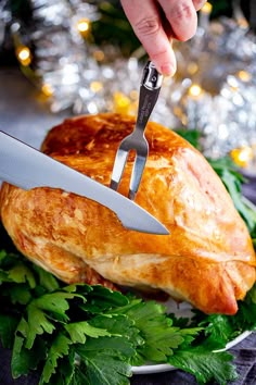 a person holding a knife cutting into a turkey