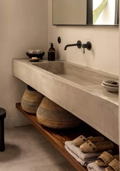 a bathroom with two sinks and towels on the shelf