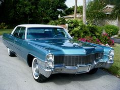 an old blue and white car parked on the street