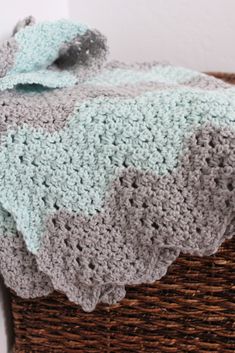 a crocheted blanket sitting on top of a basket