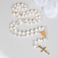 This Personalized Rosary, is ideal as a Baptism gift for a little girl or baby boy or as a gift for a special occasion. It is expertly handcrafted in a traditional style with a contemporary twist utilizing genuine Mother of pearl stone and gold-plated brass wire, which not only gives a touch of nature but also tenderness. The letter beads on the Rosary are also handmade from genuine mother of pearl, and the length is perfect to worn as a dainty Rosary necklace for women. *MATCHING ROSARY BRACELE Spiritual White Jewelry For Gifts, Spiritual White Jewelry As A Gift, Spiritual White Cross Jewelry, Pearl White Rosary With 8mm Beads As Gift, White Cross Jewelry For Gift, Round Polished Bead Rosary As Gift, White Cross Jewelry For Gifts, Polished Round Beads Rosary As Gift, White Cross Necklace For Mother's Day