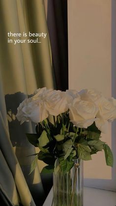 a vase filled with white roses on top of a table