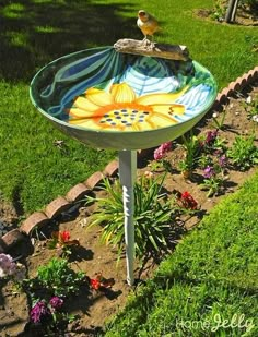 a birdbath sitting on top of a table in the middle of a garden