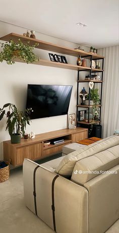 a living room filled with furniture and a flat screen tv mounted on a wall next to a window