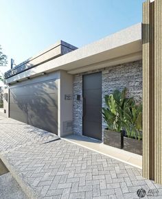 a house with two garage doors and plants in the front