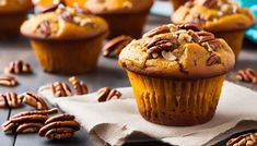 a muffin sitting on top of a napkin next to pecans