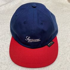 Navy Supreme Hat With Red Brim And Adjustable Nylon Back. Purchased At Nyc Supreme Store. Never Worn. Red Six-panel Fitted Hat For Streetwear, Navy Casual Snapback Hat For Streetwear, Blue Snapback Baseball Cap For Winter, Blue Six-panel Baseball Cap For Streetwear, Red Six-panel Baseball Cap For Streetwear, Blue Outdoor Hat With Embroidered Logo, Blue Dad Hat For Streetwear, Navy Hat For Streetwear, One Size Fits Most, Navy Hat For Streetwear