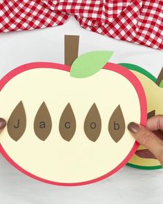 someone is holding up an apple cutout to show the word abc and od