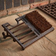 a brown brush sitting on top of a metal tray next to a drain grate