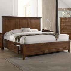 a bedroom with a bed, dressers and mirror in it's center area