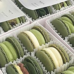 there are many green and white macaroons in the box