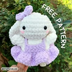 there is a small stuffed animal that is wearing a purple and white crochet dress