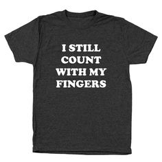 This I Still Count With My Fingers t-shirt is made from 100% breathable cotton, providing a snug and comfortable fit. Perfect for school or casual wear, this t-shirt is designed with a funny teacher-inspired message, making it a funny and stylish choice for math instructors or those who appreciate math-related humor. Funny Text Tri-blend T-shirt, Funny Cotton T-shirt, Novelty Cotton T-shirt With Letter Print, Novelty Cotton Tops With Text Print, Cotton Novelty Top With Text Print, Funny Text Print Tops For School, Novelty Cotton T-shirt With Text Print, Novelty Cotton T-shirt With Slogan, Cotton Novelty T-shirt With Slogan