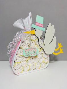 a stork carrying a baby shower cake with its name cut out on it