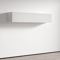 a white shelf on the wall in an empty room