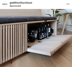 a wooden bench with bottles in it on the floor