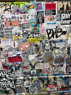 a wall covered in lots of stickers and graffiti