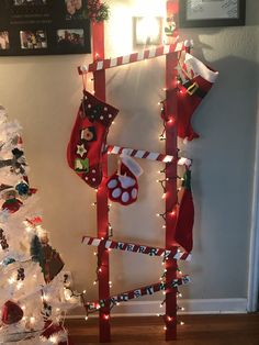 christmas stockings and stocking hanging on a wall next to a white tree with lights