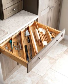 an open drawer in the middle of a kitchen