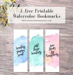 three free printable watercolor bookmarks on a wooden table